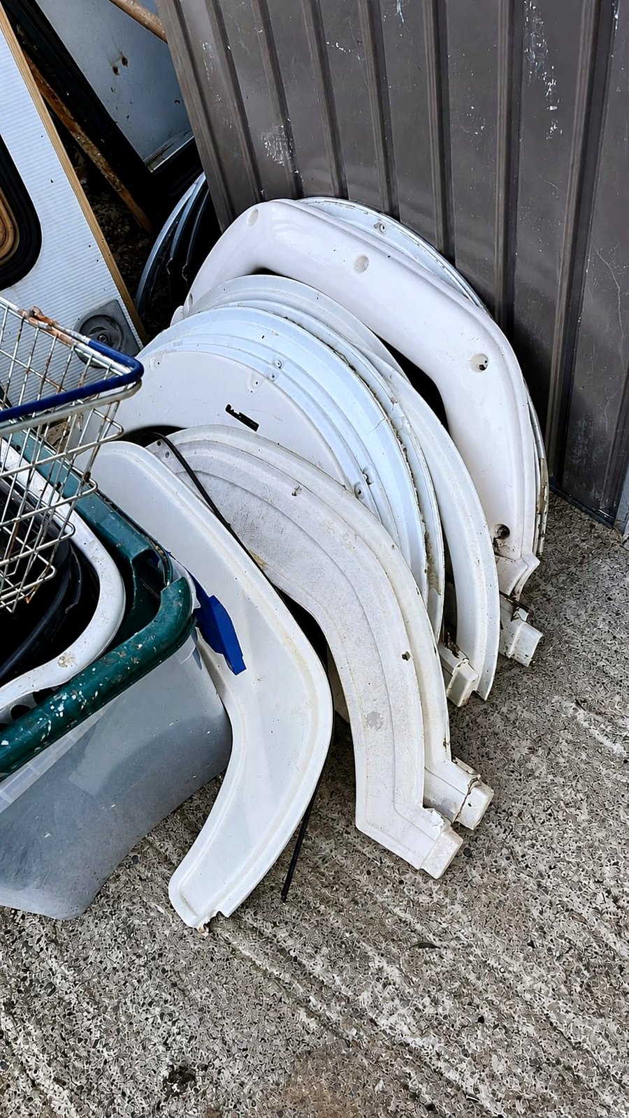 Used caravan wheel arches and exterior panels stacked at the yard