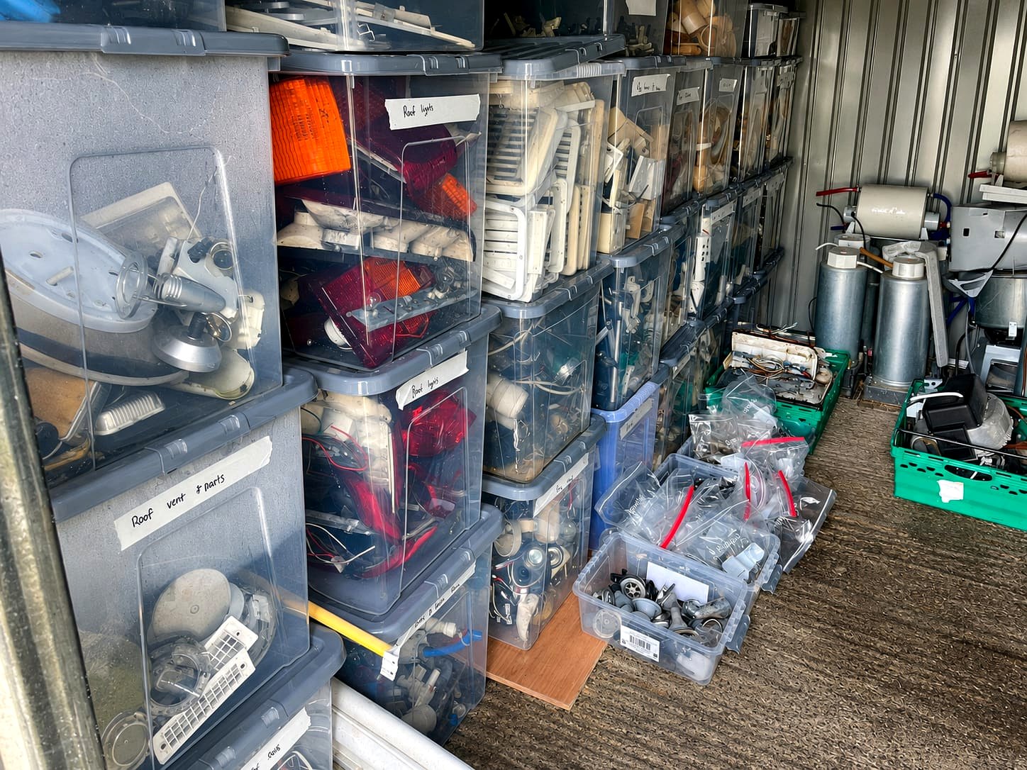 Labelled storage bins of caravan roof vents, lights, catches and fittings