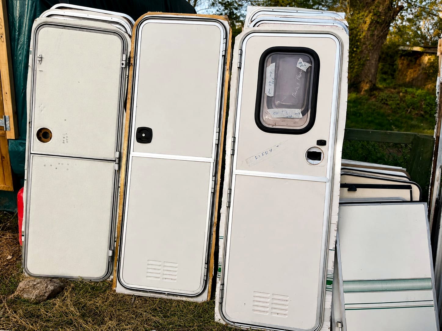 Used caravan doors stacked and sorted in the yard